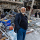 A man stands in the middle of a pile of debris in Tehran, Iran.