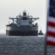 The CHIOS crude oil tanker sits on the water, a US flag waves in the foreground