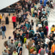 An elevated view of throngs of people in an airport terminal.