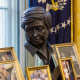 A composite of a mural in Cezar A. Chavez Memorial Park and a sculpture of Cezar Chavez in the Oval Office awaiting former President Biden.