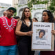 Raiza, center, holds a sign with another woman showing a picture of Dylan Lopez Contreras