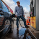 Mike Purcell poses for a portrait while inserting a gas pump into his car's gas tank at Penn Jersey Mart gas station