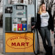 Amanda Robbins holds a gas pump at a gas station while posing for a portrait