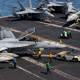 US sailors taxiing an F/A-18F Super Hornet, attached to Strike Fighter Squadron (VFA) 41, on the flight deck aboard Nimitz-class aircraft carrier USS Abraham Lincoln.