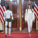 Image: First lady Melania Trump walks with a humanoid robot