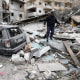 A man walks on the rubble of a destroyed building
