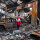 A worker with the Iranian Red Crescent Society walks through the rubble of a foreign car repair workshop on March 28 in Tehran, Iran.