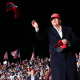 President Donald Trump tosses a MAGA hat.