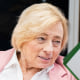Janet Mills sits and speaks to someone holding a sign over their face that reads "Janet Mills for Maine"