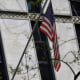 The American flag is displayed outside a non-descript marble building with slender tinted windows.