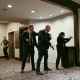 Four law enforcement agents in plainclothes with guns drawn in a conference room.