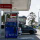 Image: Vehicles sit parked at fuel pumps as regular gasoline prices above $6 per gallon and diesel prices above $7 per gallon are displayed outside a Mobil gas station 
