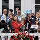 Cherie DeVaux smiles while holding a trophy surrounded by other people.