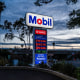 A sign displays fuel prices at a Mobil gas station