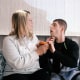Melissa Gonce sits on a bench on a porch next to Jason, she has her hand on his chin as he holds an orange toy