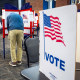People vote at voting booths inside of a room