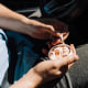 A man in a car takes out a nicotine pouch from a plastic jar