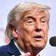 Donald Trump speaks while standing behind a podium