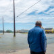 A person looks out towards a flooded neighborhood after Tropical Storm Arthur made landfall.