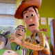 Buzz Lightyear and Woody stand next to each other in a bedroom making shocked expressions