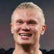 Erling Haaland smiles while standing on the football field