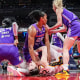 Alyssa Thomas, center, scrambles to get up over Indiana Fever guard Caitlin Clark, below her. Thomas has a fist on Clark's neck.