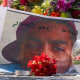 A picture of Corey Ruiz is on the ground surrounded by posters and flowers