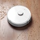 Image: Smart robot vacuum cleaner removes scattered debris from the laminate floor. The concept of a smart home, wireless cleaning of any surfaces