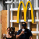 The McDonalds logo is displayed as people walk in the street.