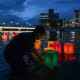 People push colorful paper lanterns out onto the Motoyasu River in Hiroshima.