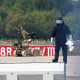 A forensic technician works alongside a bomb-disposal robot.