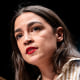 Alexandria Ocasio-Cortez speaks at a podium onstage