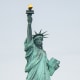 The Statue of Liberty seen from across the water on a cloudy day