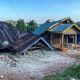 Collapsed houses are seen in daylight.