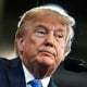 Donald Trump stands at a podium on stage