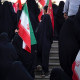 Image: A veiled pro-government supporter carrying an Iranian national flag