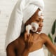 woman applying facial cleanser with a brush