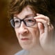 Susan Collins adjusts her glasses while seated