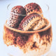 A menu stand outside of a building on the sidewalk, showing tiramisu, biscoff, and an affogato, all AI-generated illustrations