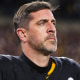 Mike Florio and Michael Holley debate the report of the Pittsburgh Steelers failing to disclose Aaron Rodgers' illness on the injury report ahead of the playoff game against the Houston Texans last season.