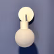 Poplight base adhered to blue wall with person holding Poplight with shade.