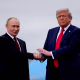 Putin, left, and Trump shake hands while standing outside