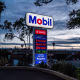 A sign displays fuel prices at a Mobil gas station