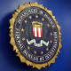 The logo of the Federal Bureau of Investigation hung on a blue wall next to an American flag