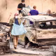 Residents carry the remains of deceased dogs at a home burned in the Old Trails fire in Spokane, Wash., on Aug. 4, 2026. 