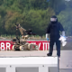 A forensic technician works alongside a bomb-disposal robot.