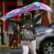 A person holds a transgender flag in the air.