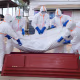 Health workers who are members of the safe and dignified burial team prepare to bury a person.
