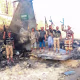 Houthi fighters stand in front of what they say is a downed Saudi jet, at a location given as Yemen