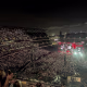 A wide shot of an outdoor stadium concert at night.